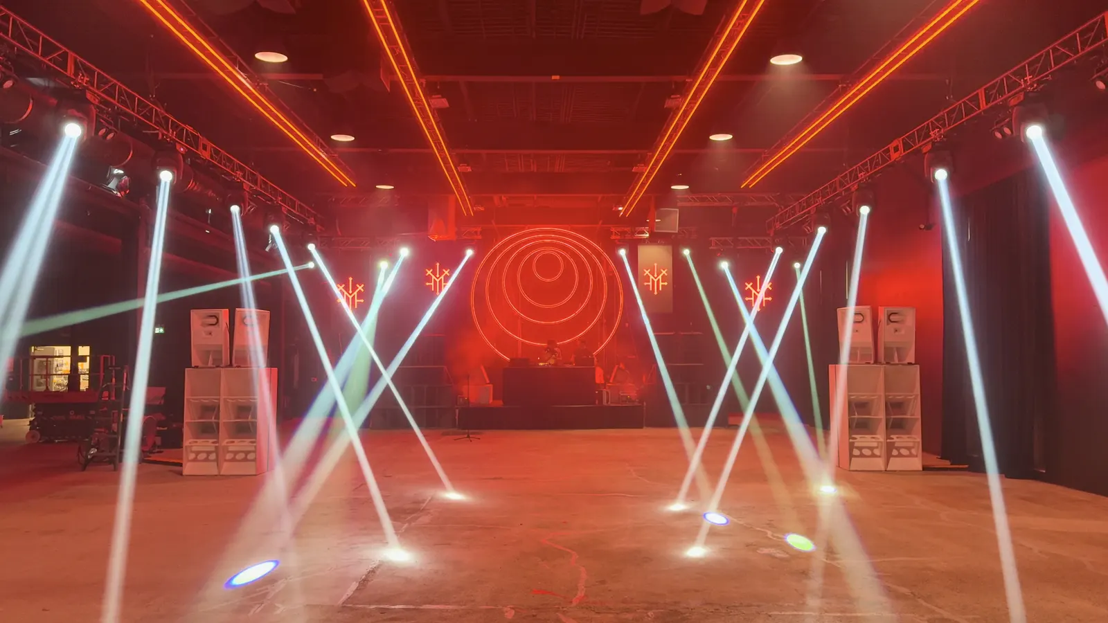 Demo Room's empty floor lit in red and orange, moving-head beams crossing the room