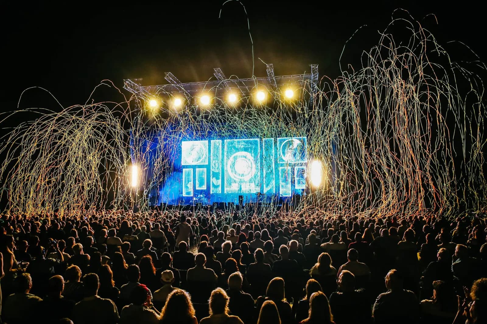 A festival main stage at night above a crowd